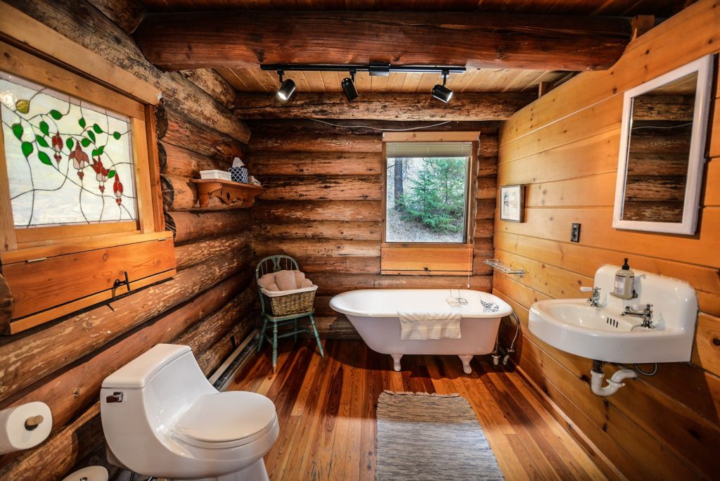 Log cabin bathroom design with natural wood walls and rustic fixtures