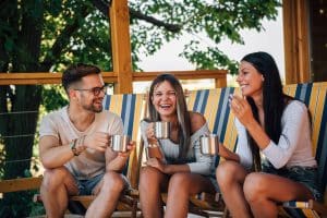 Porch design in practice: family relaxing on the covered deck of a Frontier log home