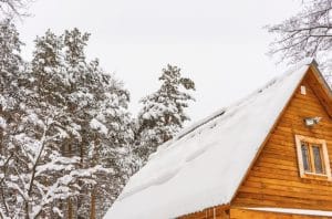 Icicles on a log cabin roof, a sign that roof energy efficiency needs attention