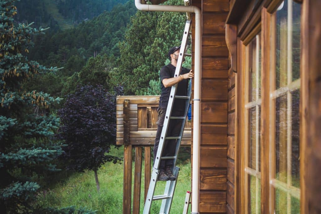 Log home in fall foliage during autumn maintenance before winter weather arrives