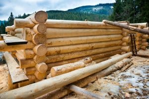 Properly dried logs stacked and ready to be cut for a cabin kit