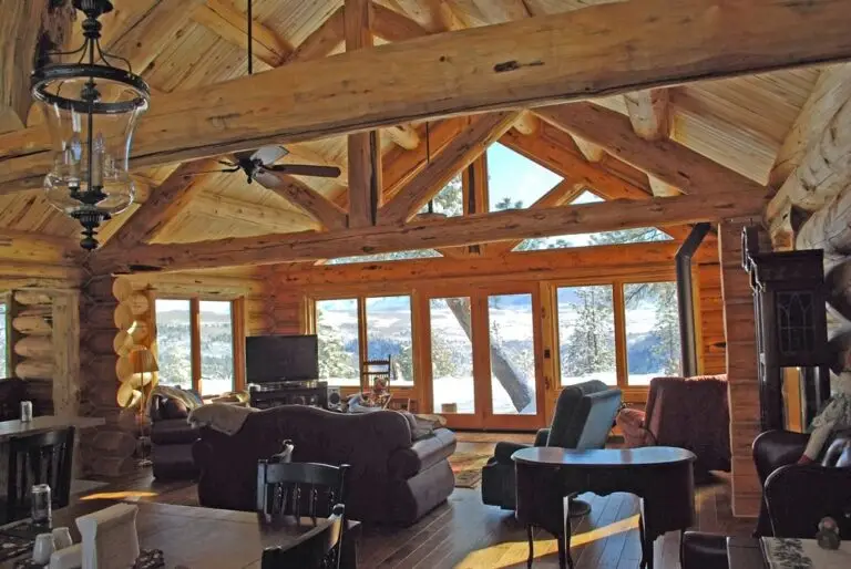Log home great room and living area with exposed logs — photo 11