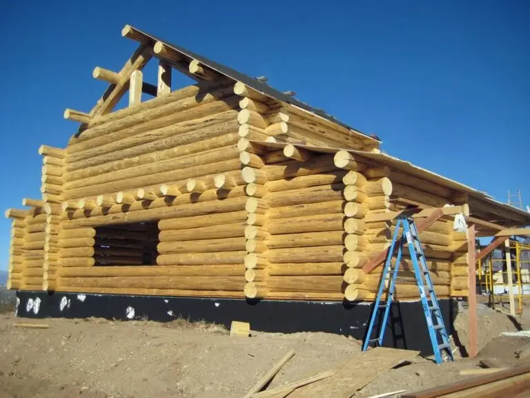Log cabin kits under construction — hand-peeled full round logs by Frontier Log Homes