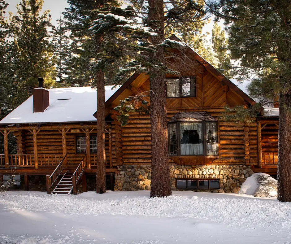 Climate impact on a log home shown in a snowy mountain setting